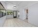 A bright, enclosed sunroom featuring tile flooring and multiple windows, leading into the kitchen at 2429 Yale Ave, Sanford, FL 32771