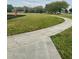 A paved path cuts through green grass with a playground and basketball court in the background at 2867 Oconnell Dr, Kissimmee, FL 34741