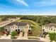 An aerial view showcases the townhomes, lush landscaping, and a serene pond at 2906 Clarabelle Ct, Kissimmee, FL 34743