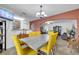 Open dining room featuring bright yellow upholstered chairs, an archway and decorative lighting at 2906 Clarabelle Ct, Kissimmee, FL 34743