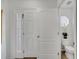 Hallway leading to a powder room, featuring tiled floors, and white doors and walls at 2906 Clarabelle Ct, Kissimmee, FL 34743