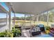 Enclosed patio with outdoor seating and potted plants overlooks a pond with lush trees at 2906 Clarabelle Ct, Kissimmee, FL 34743