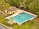 Community pool and pool house with a fence and trees, offering a recreational amenity for residents at 2906 Clarabelle Ct, Kissimmee, FL 34743