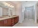 Bright bathroom features dual sinks, granite countertops, and a glass-enclosed shower at 310 Pendant Ct, Kissimmee, FL 34747