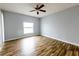 Bright, empty bedroom with wood-look flooring, light walls, and a large window providing natural light at 3209 Hanley St, Deltona, FL 32738