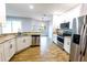 Modern kitchen features stainless appliances, granite countertops, sleek white cabinetry, and wood-look flooring at 3209 Hanley St, Deltona, FL 32738