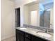 Bathroom featuring double vanity with granite countertop, dark cabinets, and a tiled shower with glass door at 398 Citrus Isle Loop, Davenport, FL 33837