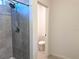 Bathroom featuring tiled walls in shower and view to adjacent toilet room at 398 Citrus Isle Loop, Davenport, FL 33837