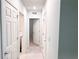 Hallway with doors leading to laundry room, bathroom and bedroom with neutral-toned walls and tile floors at 398 Citrus Isle Loop, Davenport, FL 33837