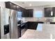 Modern kitchen with stainless steel appliances, dark cabinets, granite countertops, and tiled backsplash at 398 Citrus Isle Loop, Davenport, FL 33837