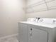 Bright laundry room featuring a white washer and dryer, and convenient overhead shelving at 398 Citrus Isle Loop, Davenport, FL 33837