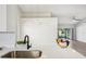 Kitchen features stainless sink and view through living area, white walls and modern lighting fixture at 413 Mainsail Ct, Lake Mary, FL 32746