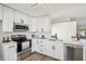 Well-lit kitchen featuring new stainless steel appliances, clean white cabinets, and sleek quartz countertops at 413 Mainsail Ct, Lake Mary, FL 32746