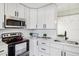 Modern kitchen with updated appliances, white cabinets, and a sleek quartz countertop with black hardware at 413 Mainsail Ct, Lake Mary, FL 32746