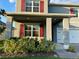 Inviting front porch with gray columns and red shutters creates a warm and welcoming entrance at 5384 Palomino Pl, Apopka, FL 32712