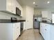 Well-lit kitchen featuring white cabinetry, stainless steel appliances, and granite countertops at 5384 Palomino Pl, Apopka, FL 32712