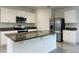 Modern kitchen featuring white cabinets, stainless steel appliances, and granite countertops on the island at 5384 Palomino Pl, Apopka, FL 32712