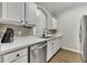 Kitchen featuring stainless steel appliances, white cabinets, light countertops, and a decorative backsplash at 581 Brantley Terrace Way # 209, Altamonte Springs, FL 32714