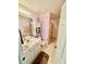 Bathroom with a white vanity, toilet, and shower with dated pink wallpaper accents at 6037 Hickory Grove Ln, Port Orange, FL 32128