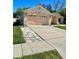 View of the home's driveway and garage with landscaping and sidewalk at 6037 Hickory Grove Ln, Port Orange, FL 32128
