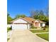 Single story home showcasing a manicured lawn and charming curb appeal on a sunny day at 6037 Hickory Grove Ln, Port Orange, FL 32128