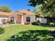 Well-maintained home with a lush green lawn, pretty landscaping, and a charming pastel color palette at 6037 Hickory Grove Ln, Port Orange, FL 32128