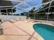 Screened-in pool area with lounge chairs, tables, and a beautifully landscaped rock garden feature at 6037 Hickory Grove Ln, Port Orange, FL 32128