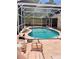Relaxing backyard pool with a screened enclosure and lounge seating for enjoying the sun at 6037 Hickory Grove Ln, Port Orange, FL 32128