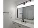 Modern bathroom with a single vanity, quartz countertop, black hardware, and large mirror at 604 Missouri Ave, St Cloud, FL 34769