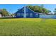 Rear exterior view of a charming blue home with a well-manicured lawn at 604 Missouri Ave, St Cloud, FL 34769