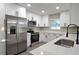 Modern kitchen with stainless steel appliances, white cabinets, and white quartz countertops at 604 Missouri Ave, St Cloud, FL 34769