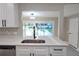 Modern kitchen showcasing white cabinets, quartz counters, and view to the pool through a pass through at 604 Missouri Ave, St Cloud, FL 34769