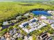 Aerial view of a lake near townhouses, tennis courts, and a green landscape at 604 Mulberry Ave # 1201, Kissimmee, FL 34747