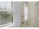 Bright bathroom shower with glass door, marble-like tiling, and window for natural light at 604 Mulberry Ave # 1201, Kissimmee, FL 34747