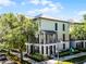 Corner lot featuring a two-story townhome with metal roof, charming balconies, and green landscaping at 604 Mulberry Ave # 1201, Kissimmee, FL 34747