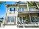 Upward view of a light green townhome featuring multiple balconies and dark gray shutters at 604 Mulberry Ave # 1201, Kissimmee, FL 34747