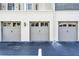 View of garages with paneled doors and decorative lanterns set against a stucco facade at 604 Mulberry Ave # 1201, Kissimmee, FL 34747