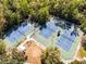 View of tennis courts surrounded by green trees and a sidewalk at 604 Mulberry Ave # 1201, Kissimmee, FL 34747