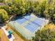 Aerial view of fenced tennis courts surrounded by lush green trees and a shaded bench area at 604 Mulberry Ave # 1201, Kissimmee, FL 34747