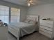 Bright main bedroom featuring light gray wood floors, a ceiling fan, and a large bed with a white headboard at 6142 Westgate Dr # 304, Orlando, FL 32835