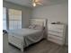 Bright main bedroom featuring light gray wood floors, a ceiling fan, and a large bed with a white headboard at 6142 Westgate Dr # 304, Orlando, FL 32835