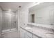 Bright bathroom with granite countertops, double sinks, and a tiled glass-enclosed shower at 6599 Lullaby Way, Mascotte, FL 34753