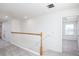 Upstairs hallway featuring neutral carpet, white walls, and white railing at 6599 Lullaby Way, Mascotte, FL 34753