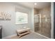 Tiled bathroom featuring a glass-enclosed shower, decorative window treatment, and relaxing bench at 6611 Lullaby Ln, Mascotte, FL 34753