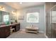 Light and airy bathroom showcasing double vanity, a tiled shower, and a relaxing bench at 6611 Lullaby Ln, Mascotte, FL 34753