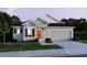 Attractive single-Gathering home showcasing a two-car garage, neutral paint, dark shutters and an inviting front yard at 6611 Lullaby Ln, Mascotte, FL 34753