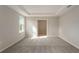 Main bedroom featuring carpet flooring, window, neutral paint, tray ceiling, and an entrance to closet at 6611 Lullaby Ln, Mascotte, FL 34753