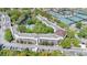 Aerial view of the community shows the pool, pond, tennis courts, and surrounding landscape at 700 Melrose Ave # L-23, Winter Park, FL 32789
