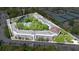 Aerial view highlights the community buildings, pool, tennis courts, parking and surrounding green area at 700 Melrose Ave # L-23, Winter Park, FL 32789