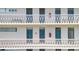 White apartment building featuring balconies with patterned railings and multiple access doors at 700 Melrose Ave # L-23, Winter Park, FL 32789